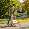 Boy outdoors using wooden Balance mee Montessori balance board on park path