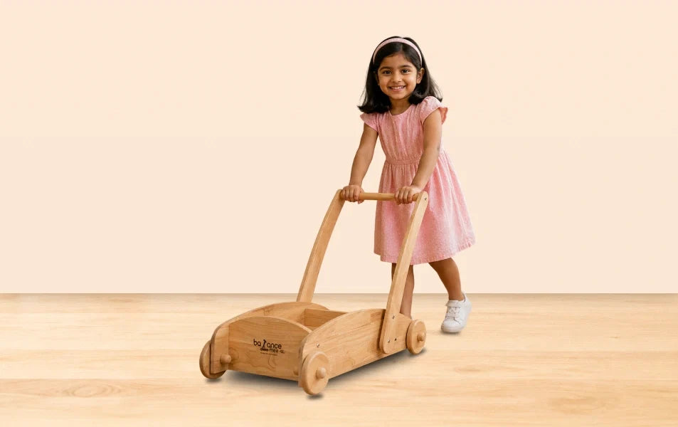 Smiling boy plays outdoors with handcrafted wooden Montessori push toy from Balance mee.