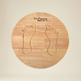 Toddler practicing coordination on a wooden wobble balance board
