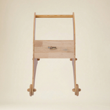Toddler practicing first steps using a safe wooden shark walker
