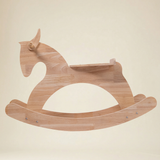 Toddler riding a wooden rocking horse indoors, demonstrating balance and coordination play 