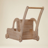 Toddler practicing first steps using a safe wooden car walker