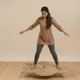 Child performing focus-based exercises on the TASK A wooden balance board