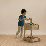 Side view of the wooden shopping cart showing sturdy wheels and handle